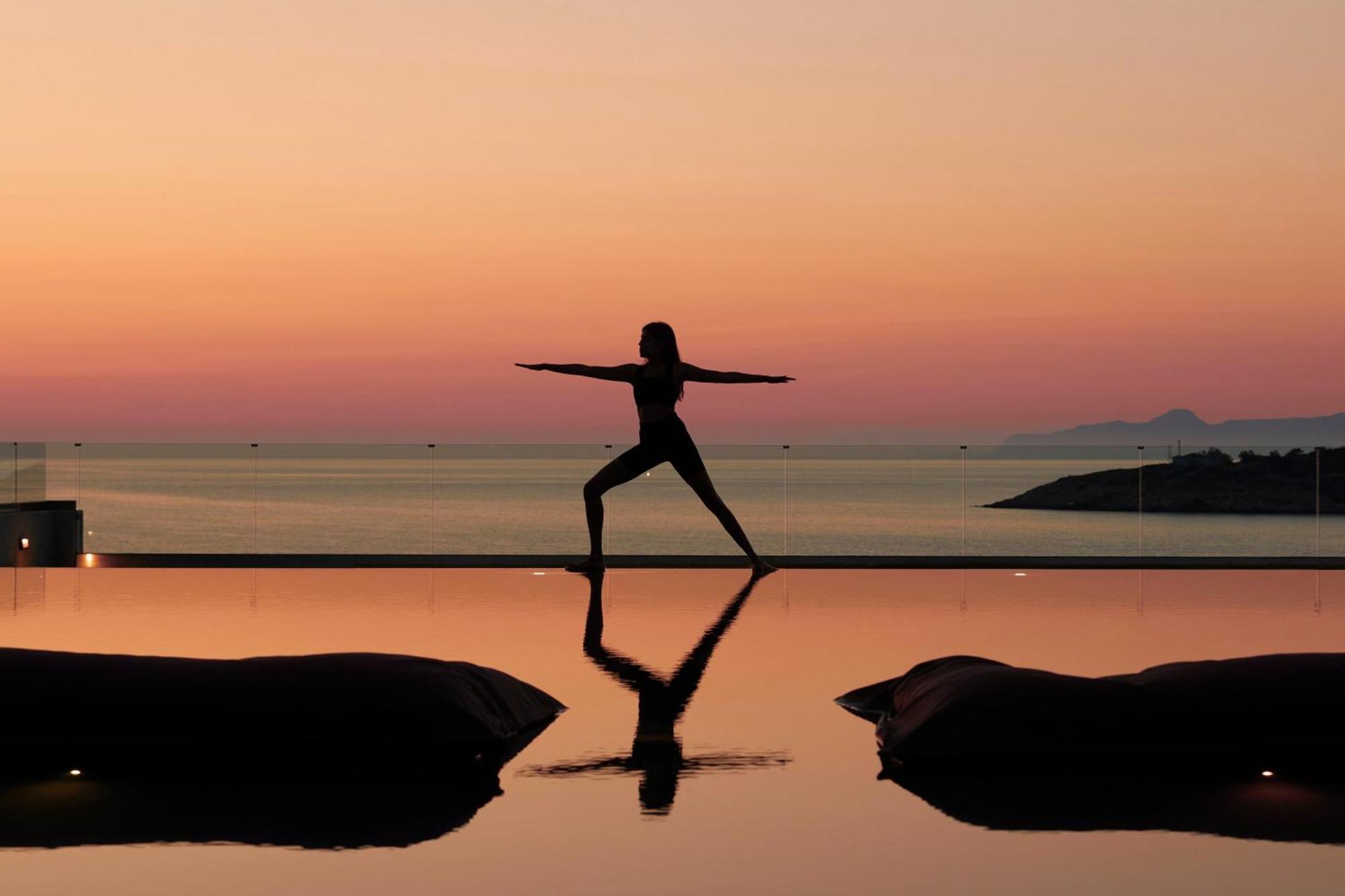 Minos Palace Resort - Adults Only Agios Nikolaos Exterior foto A woman practicing yoga at sunset